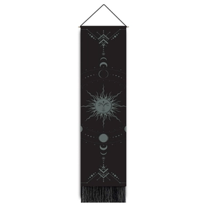 Macro detail of astrological sun totem and lunar phases on black cotton tapestry