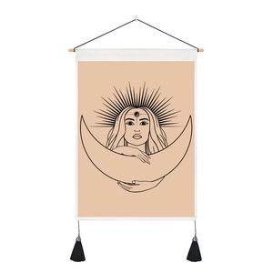 Detail of artistic moon woman tapestry with wooden pole and black tassel decorations