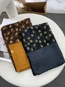 Close-up of floral print voile scarves in black and brown with elegant color-block hems