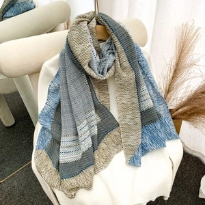 Blue and beige striped linen cotton scarf draped on a minimalist white chair