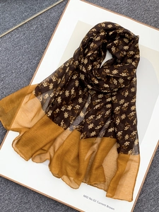 Detail of thin voile scarf with small yellow floral print and mustard yellow border trim