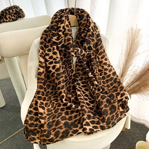 Detailed view of the leopard print pattern on a brown and black velvet winter scarf