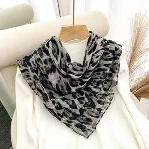 Classic leopard print square scarf in black and grey, elegantly draped on a white sweater