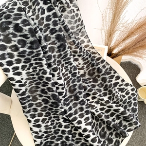Close-up of black and grey leopard print scarf texture with fine edge stitching