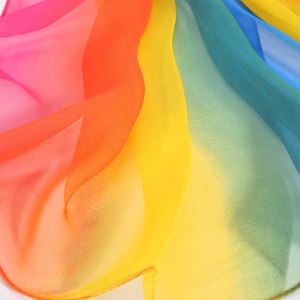 Close-up of lightweight georgette silk scarf with rainbow gradient stripes and soft texture
