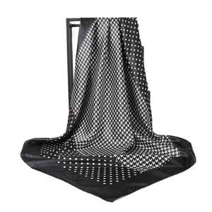Polka dot and houndstooth patterned silk scarf displayed on a black metal frame