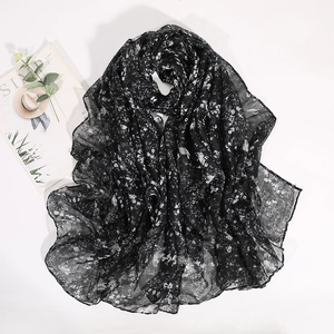 Detail of floral chiffon scarf with white small flowers on a black background