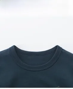 Gros plan du col rond côtelé et des coutures sur un t-shirt bleu marine enfant