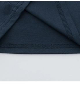 Détail de l'ourlet du t-shirt en coton bleu marine montrant la double couture et le tissu