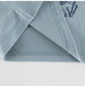 Close-up of double-needle hem stitching on kids blue cotton knit long sleeve shirt