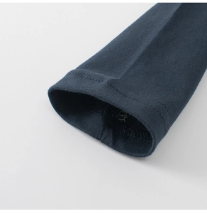 Close-up of children's long-sleeve cotton T-shirt showing navy blue cuff and stitching detail
