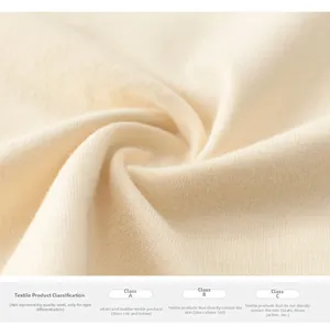 Gros plan sur tissu en maille crème montrant les normes de sécurité textile douces