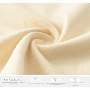 Macro detail of soft cream knitted fabric showing fine loops and safety texture