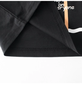 Detail of double-needle stitching and high-quality knit fabric on kids' black cotton tee