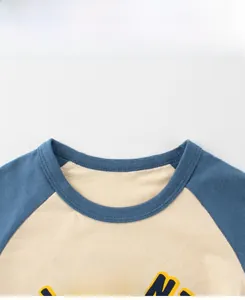 Gros plan du col rond contrasté et du tissu en coton sur le t-shirt dinosaure pour garçon