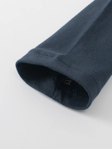Close-up of navy blue double-stitched cuffs on children's cotton long sleeve T-shirt