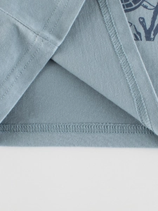 Close-up of grey-blue cotton t-shirt hem showing high-quality double stitching and fabric