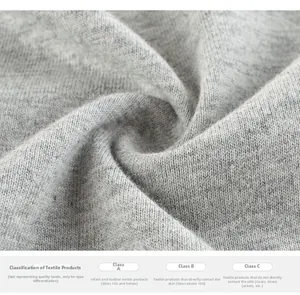Close-up of soft grey knit fabric with detailed safety standard classification text