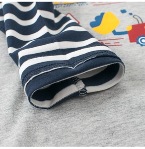 Detail of boys' striped cuffs and cotton fabric with cartoon construction truck print