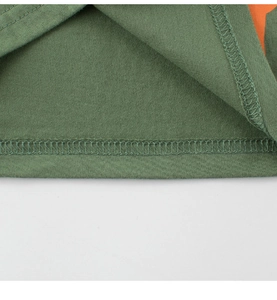 Detailed macro view of double-needle stitching on army green cotton kids t-shirt hem