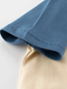 Détail de couture et tissu en coton bleu marine pour t-shirt enfant motif dinosaure