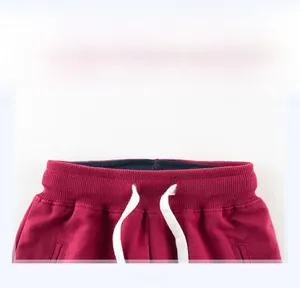 Detail show of kids burgundy sports pants featuring elastic waist and white drawstrings