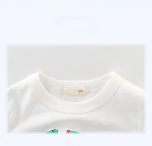 Détail de l'encolure côtelée et de l'étiquette de taille 90 du t-shirt blanc enfant