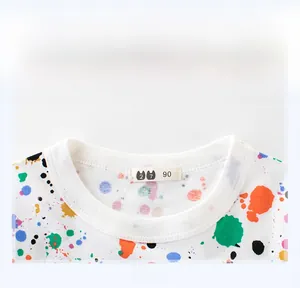 Close-up of ribbed crewneck and colorful paint splash pattern on white cotton kids T-shirt