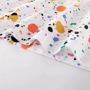 Kids cotton t-shirt featuring colorful splatter paint patterns on white fabric