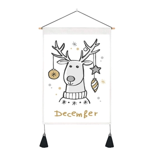 Detail of Christmas reindeer tapestry with wooden hanging rod, tassels and December text