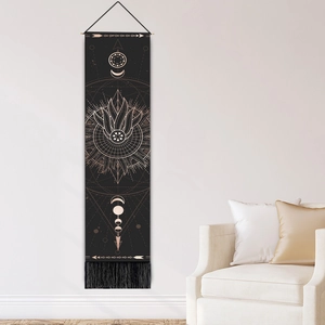 Tenture murale bohème motifs soleil lune et franges noires dans un salon minimaliste