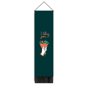 Detail of dark green tapestry with black tassels, floral hand illustration and I love you text