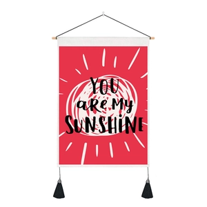 Detail of Nordic wall tapestry featuring 'YOU ARE MY SUNSHINE' print and black tassels