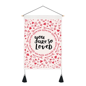 Detail of white heart tapestry with You Are So Loved print and black tassels
