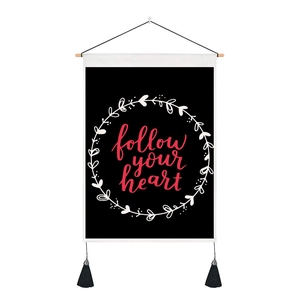 Black tapestry with follow your heart botanical wreath, wooden rod and tassels decoration