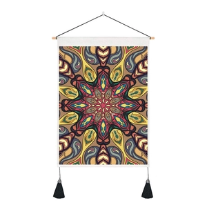 Détail de tapisserie mandala bohème avec tringle en bois et pompons en soie noire