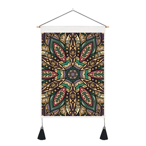Détail de la tapisserie mandala bohème avec tige en bois et pompons noirs décoratifs