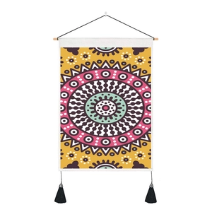 Detail of bohemian mandala wall tapestry with yellow pattern, wooden pole and black tassels