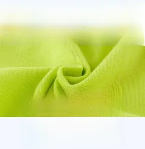 Détail du tissu en coton vert néon montrant la matière douce et respirante du t-shirt