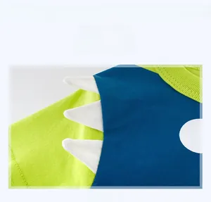 Détail de couture vert fluo et bleu marine avec appliques de dents de requin sur T-shirt enfant