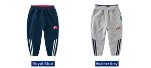 Dettaglio di joggers per bambini blu reale e grigio con ricamo e strisce bianche laterali
