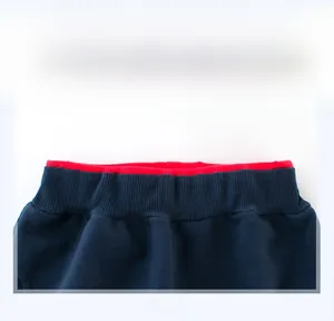 Dettaglio pantaloni sportivi blu scuro da bambino con elastico in vita e fodera rossa