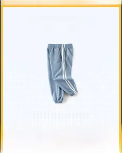 Detail of light blue boys joggers with side stripes and ribbed elastic cuffs