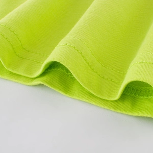 Gros plan d'un T-shirt garçon vert citron avec des finitions de couture à double aiguille