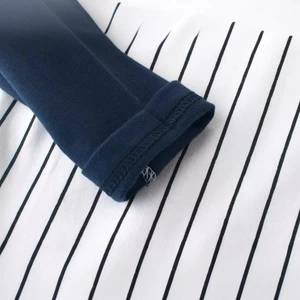 Détail du t-shirt manches longues enfant avec poignets bleu marine et tissu rayé noir et blanc