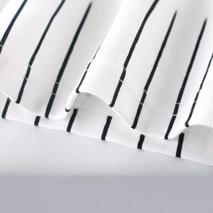Détail de l'ourlet du t-shirt à rayures en coton pour garçons avec coutures de qualité