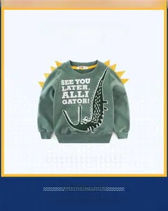 Detailed view of green sweatshirt featuring crocodile print and 3D dinosaur back scales