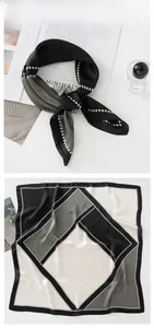Dettaglio di un foulard in seta con motivi geometrici color block e finitura satinata