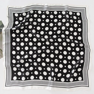 Elegant black and white polka dot square silk scarf with a smooth finish and rolled edges