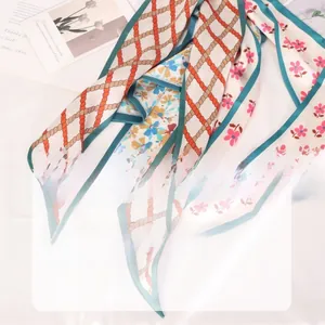 Detailed close-up of floral satin scarf with invisible stitching and elegant chain patterns